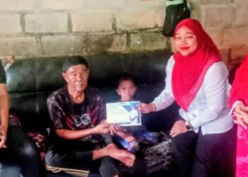 Norsarfinaz Mohd Azman menyampaikan bantuan Kerajaan Negeri Pahang kepada Mat Noh Mohamed di Felda Kota Gelanggi Empat, Jerantut baru-baru ini. – utusan/HARIS FADILAH AHMAD