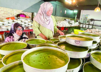 SOM Abdul Halim bersama Yusrina Muhamad Yusuf menunjukkan kuih talam di premis perniagaan mereka di Jitra, Kubang Pasu, Kedah.
