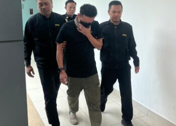 TERTUDUH (dua dari kanan) di bawa keluar dari Mahkamah Sesyen Kangar, Perlis, selepas menghadapi pertuduhan memberi suapan kepada anggota polis pada 2022 lalu. -UTUSAN/ASYRAF MUHAMMAD