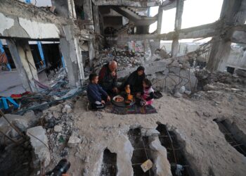 KELUARGA Palestin berkumpul dan menikmati hidangan berbuka puasa, di tengah kemusnahan di kem pelarian Bureij di tengah Gaza.- AFP