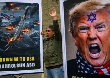 SEORANG penunjuk perasaan melaungkan slogan di sebelah gambar Presiden Donald Trump semasa demonstrasi anti-Amerika di hadapan konsulat AS di Istanbul, kelmarin.- AFP