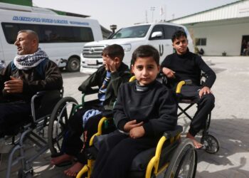 PESAKIT-pesakit Palestin duduk di kerusi roda menunggu untuk dipindahkan keluar dari Gaza melalui pintu sempadan Rafah dengan Mesir di kawasan Hospital Bulan Sabit Merah, Khan Younis.- AFP