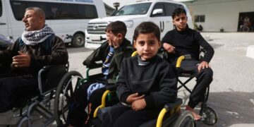 PESAKIT-pesakit Palestin duduk di kerusi roda menunggu untuk dipindahkan keluar dari Gaza melalui pintu sempadan Rafah dengan Mesir di kawasan Hospital Bulan Sabit Merah, Khan Younis.- AFP