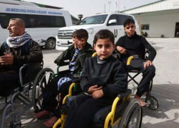 PESAKIT-pesakit Palestin duduk di kerusi roda menunggu untuk dipindahkan keluar dari Gaza melalui pintu sempadan Rafah dengan Mesir di kawasan Hospital Bulan Sabit Merah, Khan Younis.- AFP