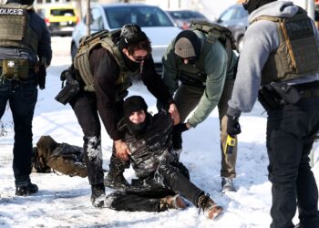 EJEN-ejen persekutuan menahan seorang penunjuk perasaan terhadap operasi imigresen oleh pentadbiran Trump di Minneapolis, Minnesota.- AFP