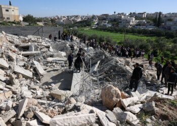 PENDUDUK Palestin melihat runtuhan rumah dan premis perniagaan yang dirobohkan jentolak di Beit Aawa, barat bandar Hebron di Tebing Barat.- AFP