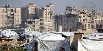 SEORANG lelaki duduk di luar khemah berhampiran bangunan yang rosak di kem pelarian Maghazi untuk pelarian Palestin, tengah Gaza. - AFP