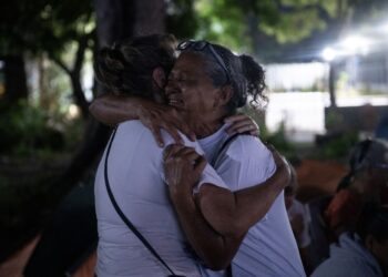 AHLI keluarga tahanan politik berpelukan ketika menonton siaran langsung ucapan Timbalan Dewan Negara, Jorge Rodriguez, mengenai rang undang-undang pengampunan di luar penjara El Rodeo I di Guatire, negeri Miranda, kelmarin.- AFP