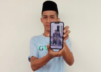 MOHD. Khairil Md. Rahim menunjukkan gambar perkahwinannya ketika ditemui di Unit Forensik Hospital Machang, Machang, Kelantan.