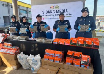 ISMAIL Hashim (tiga dari kanan) menunjukkan ketulan mampat dipercayai ganja yang dirampas pada sidang media di Pejabat Kastam Kuala Perlis, Perlis, hari ini. -UTUSAN/ASYRAF MUHAMMAD