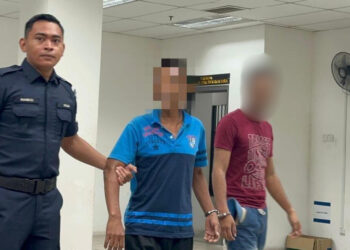 ANGGOTA  polis membawa Muhammad Aniq (kanan) untuk pendakwaan atas pertuduhan mencederakan isterinya di Mahkamah Majistret Kota Bharu, Kelantan, hari ini.
