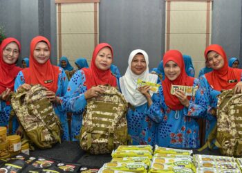 SITI Juana Md Ibrahim (empat dari kiri) bersama ahli  Badan Kebajikan Angkatan Tentera (Bakat) sewaktu menyiapkan pembungkusan  16,000 beg sumbangan Hari Raya Aidilfitri untuk Angkatan Tentera Malaysia (ATM) yang akan bertugas di perbatasan semasa sambutan perayaan itu.