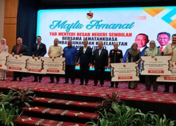 AMINUDDIN Harun (tujuh dari kanan) bergambar bersama para pegawai daerah di negeri ini sebagai wakil penerima geran pada Majlis Amanat Menteri Besar Bersama Kepimpinan Jawatankuasa Pembangunan dan Keselamatan Kampung (JPKK) Negeri Sembilan 2025-2027 di Seremban hari ini. - UTUSAN/NAZARUDIN SHAHARI