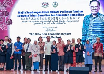 ANWAR Ibrahim (tengah) bergambar bersama pelajar yang menerima Sumbangan Kasih Madani di SMJK Yuk Choy di Ipoh hari ini.