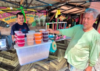 ABU Bakar Zainal Abidin (kiri) menjual buah kabung di tepi jalan 
di Kampung Kepayang di Kampung Gajah di Pasir Salak, Perak. -UTUSAN/AIN SAFRE BIDIN