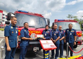 SAYANI Saidon (tiga dari kiri) menyampaikan replika kunci jentera bomba kompak atau Compact Fire Rescue Tender (CFRT) kepada Ketua Balai Bomba dan Penyelamat (BBP) Lenggong, Muhammad Shukur Jamaludin (dua dari kiri) selepas Majlis Perbarisan Tahunan Tahun 2026 di Ibu Pejabat JBPM Perak di Bandar Meru Raya, Ipoh hari ini.