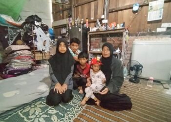 SITI Khatijah Sabri (kanan) bersama empat anaknya di ‘rumah kotak’ mereka di Kampung Payung, Setiu, Terengganu. – UTUSAN/WAN ZURATIKAH IFFAH WAN ZULKIFLI