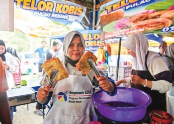 SITI Fatiema Abdul Manan menunjukkan kuih Telur Kubis Pulau Redang yang dijual digerainya di Bazar Ramadan Batu Buruk, Kuala Terengganu, Terengganu. – UTUSAN/PUQTRA HAIRRY