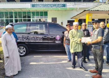 YUDITH Baharim Baharudin (kanan) menyerahkan geran van jenazah kepada Mohd. Yasad Abdul Aziz di pekarangan Masjid As-Salam Mukim Bendang Kerian, Tumpat, Kelantan, - UTUSAN/ROHANA ISMAIL