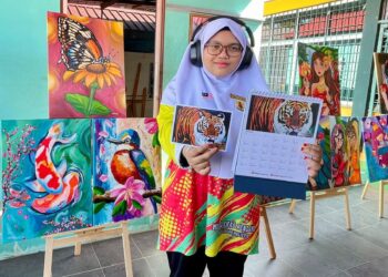 AINUL Syeefa Zamrol menunjukkan lukisan karyanya yang menghiasi kalendar sebuah bank ketika ditemui di Sekolah Model Khas Bukit Jenun, Pendang, Kedah, semalam.