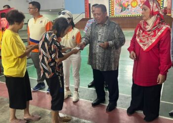 ABU Bakar Hamzah (dua dari kanan) menyampaikan sumbangan kepada salah seorang penerima pada majlis penyerahan yang berlangsung di Dewan Tokong Eng Aun Keong, Kuala Perlis, Kangar, Perlis, hari ini. -UTUSAN/ASYRAF MUHAMMAD