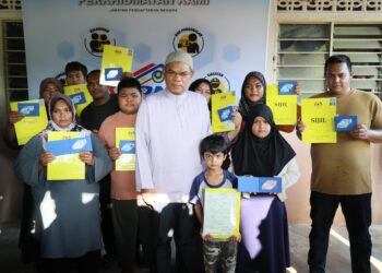 SAIFUDDIN Nasution Ismail (tengah) bersama sembilan sekeluarga yang menerima MyKad dan sijil kelahiran menerusi Program Menyemai Kasih Rakyat (MEKAR) JPN di Kampung Simpol Belubang, Machang, Kelantan hari ini-UTUSAN/KAMARUL BISMI KAMARUZAMAN