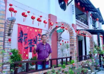 LEE Kok Heng di tepi rumahnya di Pengkalan Kempas, Negeri Sembilan yang dipenuhi dengan hiasan sempena Tahun Baharu Cina.