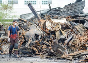 SEORANG anggota bomba dan penyelamat berjalan melalui timbunan kerangka besi yang runtuh akibat kebakaran gudang getah Miroad Rubber yang berjaya dipadam sepenuhnya di kawasan perindustrian Sengkang, Kulai, Johor, semalam. – UTUSAN/RAJA JAAFAR ALI