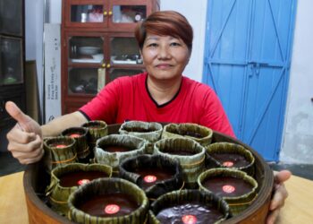 LIM Siow Wah bersama tempahan kuih bakul yang dihasilkannya ketika ditemui di rumahnya di Pekan Pengkalan Kempas, Port Dickson.-UTUSAN / NOR SHAFIQAH MOHD. GHAZALI