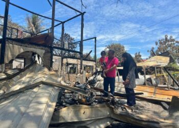 SITI Hajar Hassan (kanan) dan suami, Hasnul Hadi Yahya bersama anak hanya mampu melihat keadaan rumah mereka yang musnah dalam kebakaran di Jalan Sungai Padang, Arau, Perlis semalam.– UTUSAN/ASYRAF MUHAMMAD