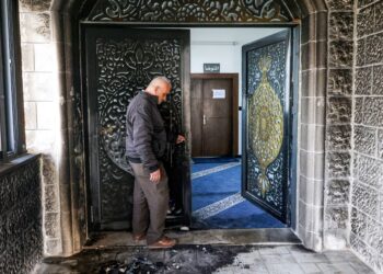 Seorang lelaki memeriksa pintu masuk yang terbakar di Masjid Abu Bakr Al-Siddiq Mosque di kampung Tell, barat Nablus semalam. - AFP.