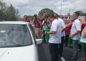 MOHAMAD Fazli menyampaikan cenderahati kepada pengguna jalan raya di Jambatan Gelang Patah - Pendas, Iskandar Puteri, hari ini