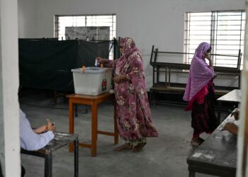 SEORANG wanita memasukkan kertas undi di sebuah pusat pengundian di Dhaka hari ini. - Foto AFP