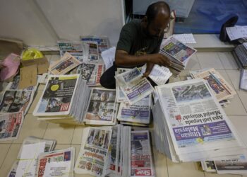 Vendor surat khabar sedang menyusun surat khabar sebelum dijual dan diedar kepada pembeli  di sekitar Lembah Klang, di Jalan Leboh Ampang, Kuala Lumpur. Gambar ini diambil pada tahun 2024. – MINGGUAN/SHIDDIEQIIN ZON