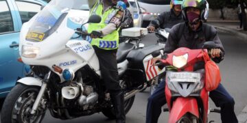 GAMBAR fail anggota polis bercakap dengan penunggang motosikal di Jakarta. - Foto AFP