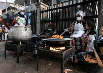 SEORANG penjaja memasak makanan untuk dijual pada hari pertama Ramadan di Lagos, Rabu lalu. - Foto AFP