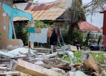 NORAINI Nawi bersama anaknya termenung mengenangkan nasib mereka yang terpaksa berlindung dan menyambut Ramadan di rumah yang runtuh di Kampung Jubakar, Tumpat, Kelantan. – UTUSAN/KAMARUL BISMI KAMARUZAMAN