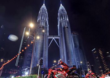 Pelumba pasukan Honda HRC Castrol, Luca Marini (kiri) bersama rakan sepasukan, Joan Mir menunggang motosikal berkuasa tinggi melalui Jalan Ampang dan Jalan P. Ramlee, 
Kuala Lumpur pada Majlis Pelancaran MotoGP Musim 2026 di Menara Berkembar Petronas, kelmarin. – UTUSAN/FARIZ RUSADIO