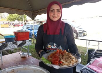 JULIA Farah Mazura Abdullah menunjukkan nasi beriani dijualnya di Kampung Wakaf Tengah, Kuala Nerus, Terengganu.
