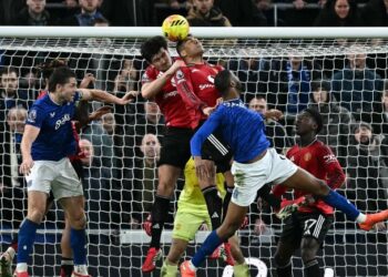 Pemain pertahanan Manchester United, Harry Maguire dan rakan sepasukan, Casemiro berlaga kepala ketika cuba mengeluarkan bola dari kawasan bahaya dalam saingan Liga Perdana Inggeris menentang Everton, semalam. - AFP