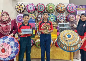 Noraliza Yusof (kiri) bersama pelajar autisme yang menghasilkan produk kraf tangan yang berkualiti tinggi.