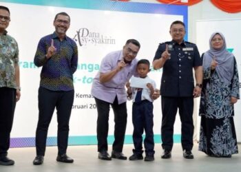 AMIZAR Abu Adam ( tiga kiri) menyampaikan bantuan kembali ke sekolah   sempena program  tanggungjawab sosial korporat PETRONAS di Felda Kemasul, Pelangai Bentong baru- baru ini.