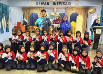 Rosie Rafidah Rahmat (kanan) bersama Zamri Ahmad bergambar kenangan bersama murid-murid Pra Sekolah pada penyampaian pingat FUN RUN SPARKS 2026 di Dewan Inspirasi, SK Parit Kasan, Tangkak, Johor, baru-baru ini.