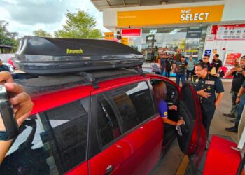 AZMAN Adam (kanan) menyantuni pelanggan yang mengisi petrol di sebuah stesen minyak berhampiran sempadan Malaysia-Thailand, Rantau Panjang, Kelantan hari ini-UTUSAN/YATIMIN ABDULLAH.