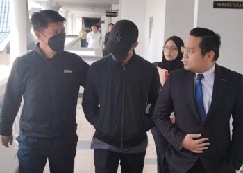 TERTUDUH diiringi anggota SPRM keluar dari Mahkamah Sesyen Ayer Keroh selepas dijatuhi hukuman denda RM210,000 selepas mengaku bersalah atas 20 pertuduhan menerima suapan pinjaman perumahan.