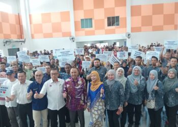 MOHD. Jafni (tengah) bergambar bersama penerima Bantuan Kasih Johor Fasa 3 di Dewan PPR Sri Stulang, Johor Bahru, Johor, semalam.