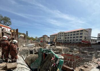 BEBERAPA anggota bomba (kiri) melihat keadaan sebuah lori simen yang terbalik sehingga meragut nyawa pemandunya dalam satu kejadian di sebuah kawasan tapak pembinaan berhampiran Hospital Pulau Pinang (HPP), hari ini.-IHSAN JBPM PULAU PINANG