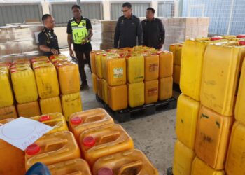 S. JEGAN (dua dari kiri) menunjukkan barangan rampasan hasil kegiatan penyelewengan minyak masak bersubsidi dalam serbuan sebuah stor di Tasek Gelugor, ketika sidang media di Stor Penyimpanan Eksibit KPDN Pulau Pinang di Bukit Minyak, Bukit Mertajam, Pulau Pinang.-UTUSAN/DANIAL SAAD