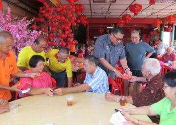 MOHD. Syahbuddin Hashim menyampaikan angpau kepada warga emas yang hadir ke Tokong Kuan Tai Meow, Kampung Baru, Gua Musang, Kelantan.