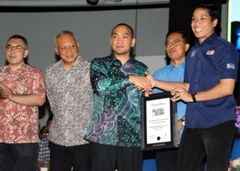 ONN Hafiz Ghazi menerima sijil MBOR sambil diperhatikan oleh A. Rahim Nin (dua dari kanan) sempena Festival Layang-layang Sedunia Pasir Gudang di Bukit Layang-layang, semalam.- UTUSAN/RAJA JAAFAR ALI